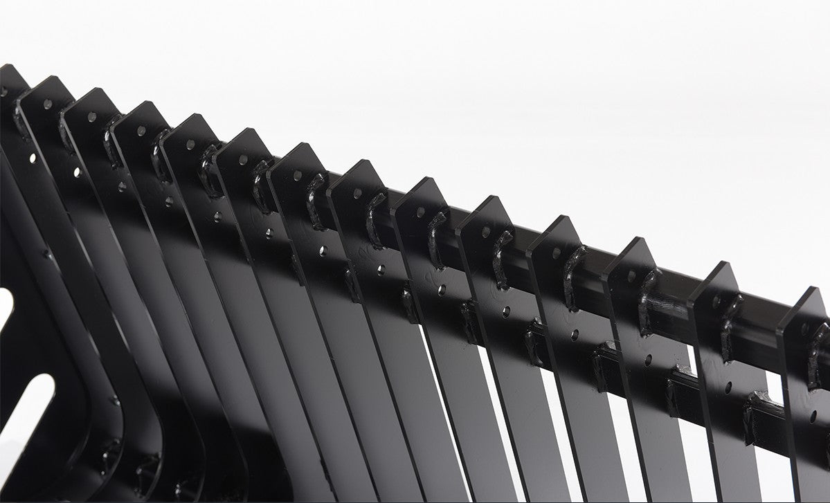 Close-up of Vestil skid steer rock grader attachment showing rugged metal blade and mounting components for heavy machinery.