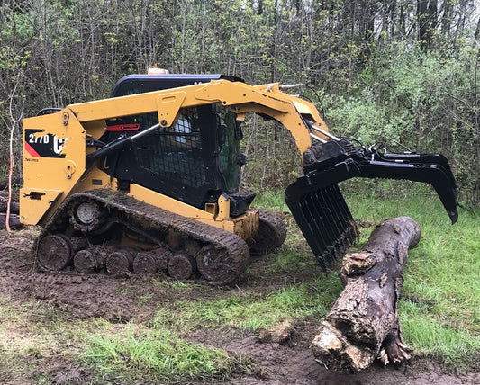 Vestil skid steer grab bucket attachment connected to heavy machinery for lifting and transporting materials.